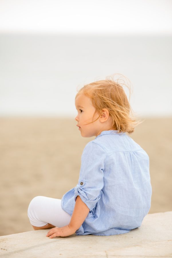 Pretty blond girl sitting overlooking the sea